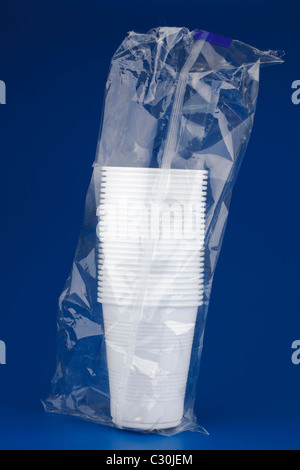 Clear plastic cup stacked on blue jelly container on perforated table ...