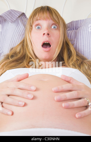 Pregnant woman in bed feeling contractions. Stock Photo