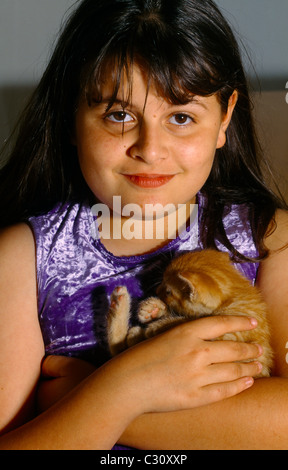 Young Girl Cuddling A Ginger Kitten Stock Photo