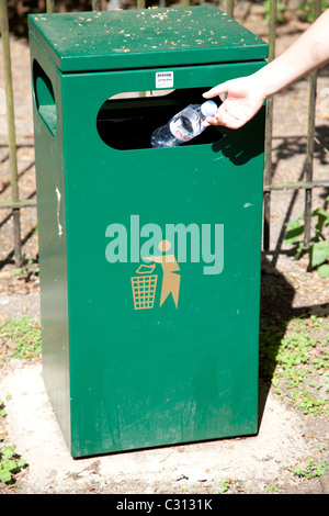 A young person throwing an empty bottle of water in to a dustbin Nottingham England UK Stock Photo