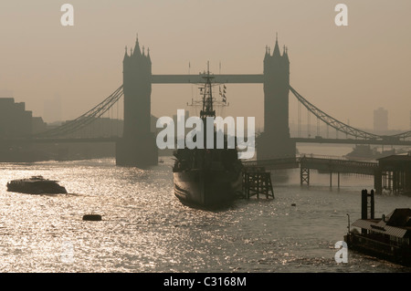 Tower Bridge and Hms Belfast in early morning smog,London,England Stock Photo