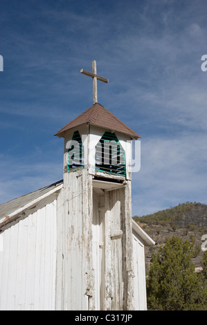 The old wooden bell tower of San Ysidro church reaches to the blue heavens in the Hondo Valley, New Mexico. Stock Photo