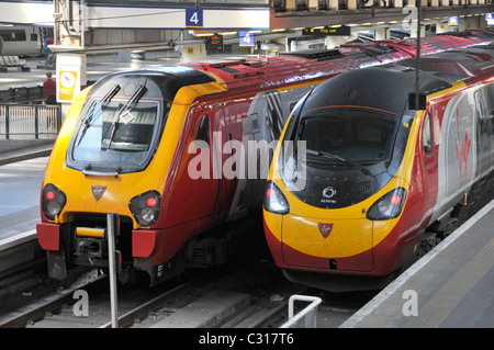 Two streamlined Virgin train units operated by Virgin Trains at Euston railway station platforms London England UK provide inter city public transport Stock Photo