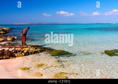An old fisherman is looking at the sea in the beach Es Calo des Mort in the island of Formentera (Balearic islands, Spain). Stock Photo