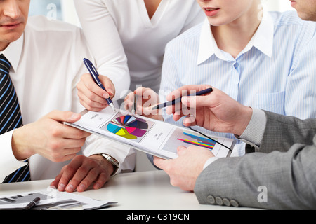 Image of several hands of working partners discussing business charts Stock Photo