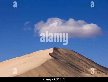 Cloud over desert sand dune - Kelso Dunes, Mojave desert, California USA Stock Photo