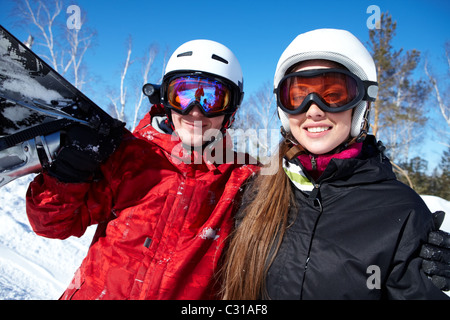 Portrait of happy couple of snowboarders outside during winter vacations Stock Photo