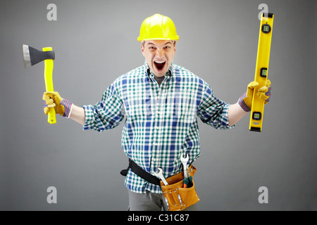 Portrait of crazy architect worker with axe and level measuring device Stock Photo