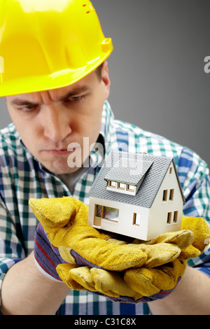 Portrait of a serious architect holding a house model Stock Photo