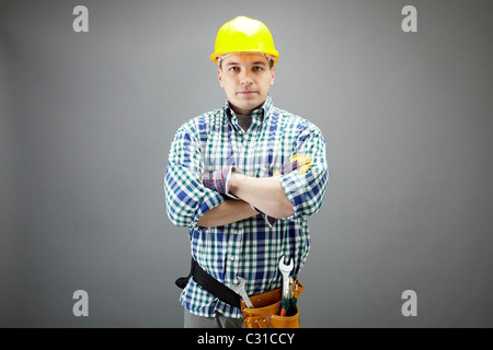 Portrait of confident worker in helmet isolated on grey Stock Photo