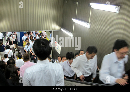 HURRYING SALARYMEN USING THE RIGHT SIDE OF THE ESCALATORS IN THE METRO AT RUSH HOUR, TOKYO, JAPAN Stock Photo