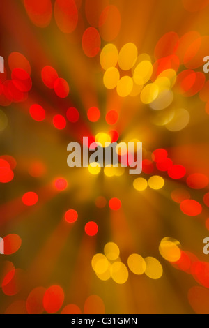 Abstract of colorful red and gold circles with light rays radiating from center Stock Photo