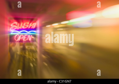 Sushi Open neon sign in window with streaks of light radiating our from sign and interior light Stock Photo