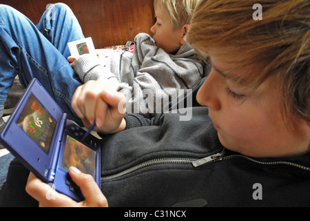CHILDREN PLAYING VIDEO GAMES (NINTENDO DS CONSOLE), EACH TO HIS OWN Stock Photo