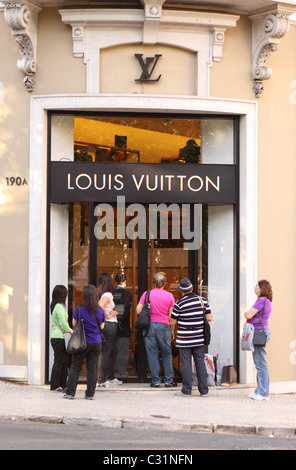 Louis Vuitton Lisbon Portugal shoppers wait outside the  fashion shop on the Avenida da Liberdade in Lisboa Portugal Stock Photo