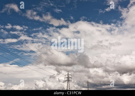 High Voltage Pylon against blue sky and clouds Stock Photo