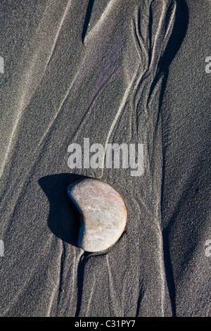 Water erosion and a pebble form an abstract design in the sand at Kalaloch Beach, Olympic National Park, Washington. Stock Photo