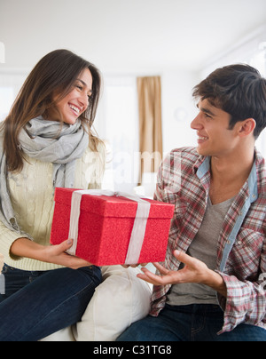 Woman handing husband Christmas gift Stock Photo