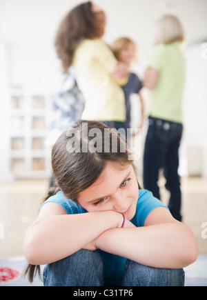 Lonely girl ignoring friends playing Stock Photo