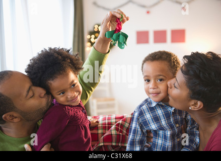 Black father holding mistletoe over daughter's head Stock Photo
