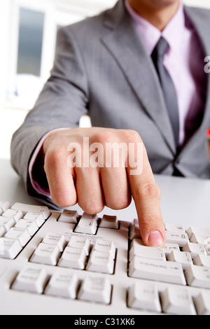 Close-up of businessman sitting at the table and typing a letter Stock Photo