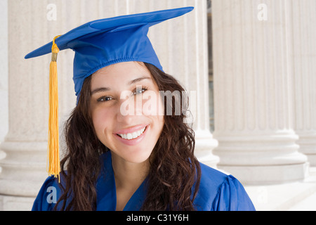 Mixed race woman wearing graduation cap and gown Stock Photo