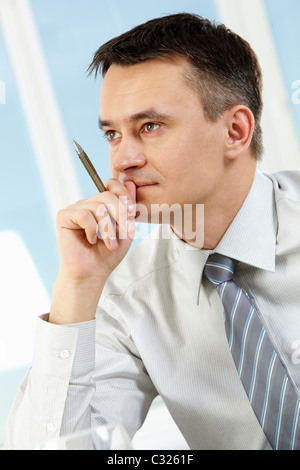 Photo of handsome businessman with pen in hand under inspiration Stock Photo