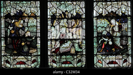 A stained glass window by C E Kempe & Co. depicting The Adoration of the Shepherds Stock Photo