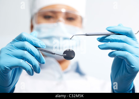 Image of assistant in medical uniform holding dentistry tools in hands Stock Photo