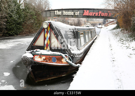 Canal boat frozen in at mooring Stock Photo