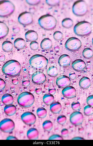 Envelope symbol reflected in the drops of water. Close-up of water droplets placed on a DVD disc Stock Photo