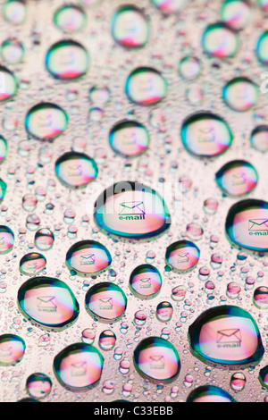 Envelope symbol reflected in the drops of water. Close-up of water droplets placed on a DVD disc Stock Photo