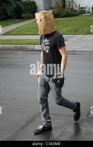 Shia LaBeouf tries to hide his identity by wearing a paper bag mask and plastic bag over his wrist cast as he takes a stroll Stock Photo