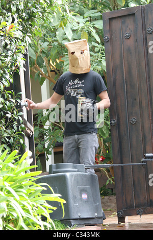 Shia LaBeouf tries to hide his identity by wearing a paper bag mask and plastic bag over his wrist cast as he takes a stroll Stock Photo