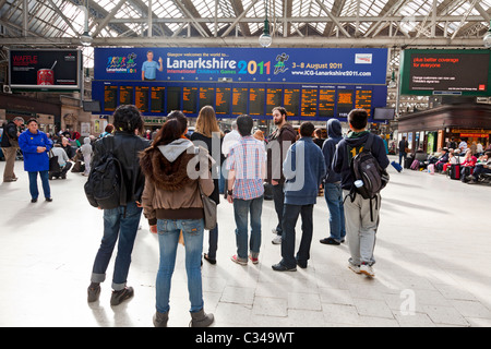 Passengers waiting for trains watching the departures board at Glasgow Central Station, Scotland, UK Stock Photo