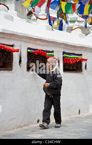 Tibetan devotee turning prayer wheel at Bouddhanath Stupa Stock Photo