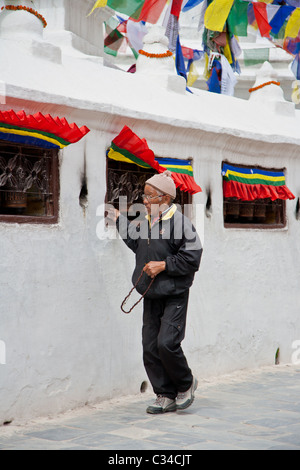 Tibetan devotee turning prayer wheel at Bouddhanath Stupa Stock Photo