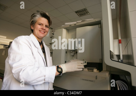 Laboratory researcher next to DNA sequencer testing machine Stock Photo