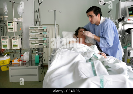 Male nurse taking care of patient in an hospital bed Stock Photo