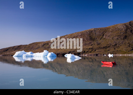 Icebergs and a boat, close to Inneruulalik Farm, South Greenland Stock Photo