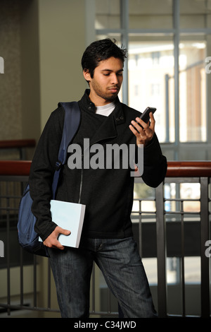 Portrait of young Indian student using cell phone indoors Stock Photo