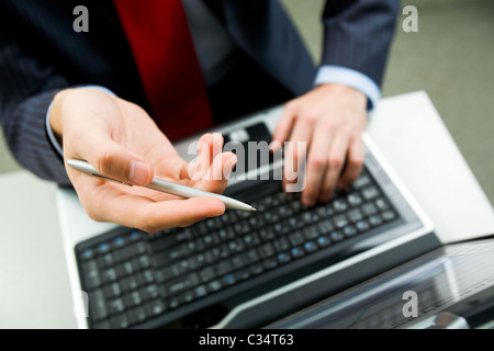 Above angle of male hand with pen pointing at laptop screen during discussion Stock Photo