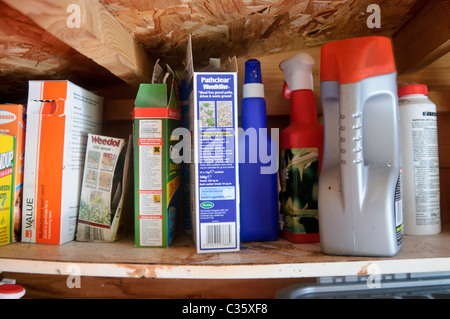 Shelf in an old shed containing various weedkillers and pest control Stock Photo