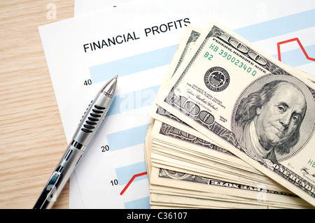 dollars with document showing financial profits Stock Photo