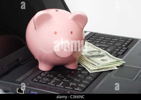 Conceptual image of piggy bank, US dollars and laptop - internet banking Stock Photo