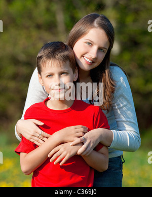 portrait of brother and sister outdoor holding each other Stock Photo