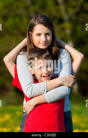 portrait of brother and sister outdoor holding each other Stock Photo