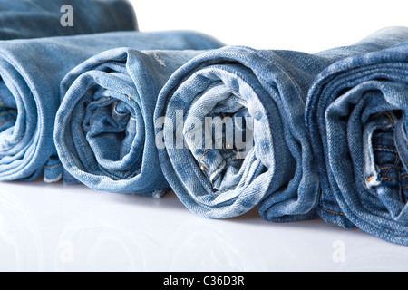 roll blue denim jeans arranged in line, isolated on white Stock Photo