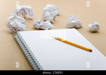 crumpled paper and yellow pencil on notebook Stock Photo