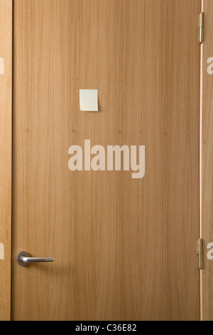 wooden door with a post-it stick on it Stock Photo